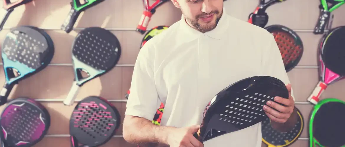 afbeelding van een man die het gewicht controleert van zijn padel racket